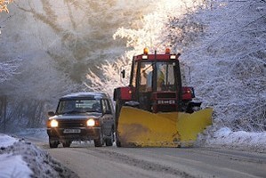 Car going around a plow on the road