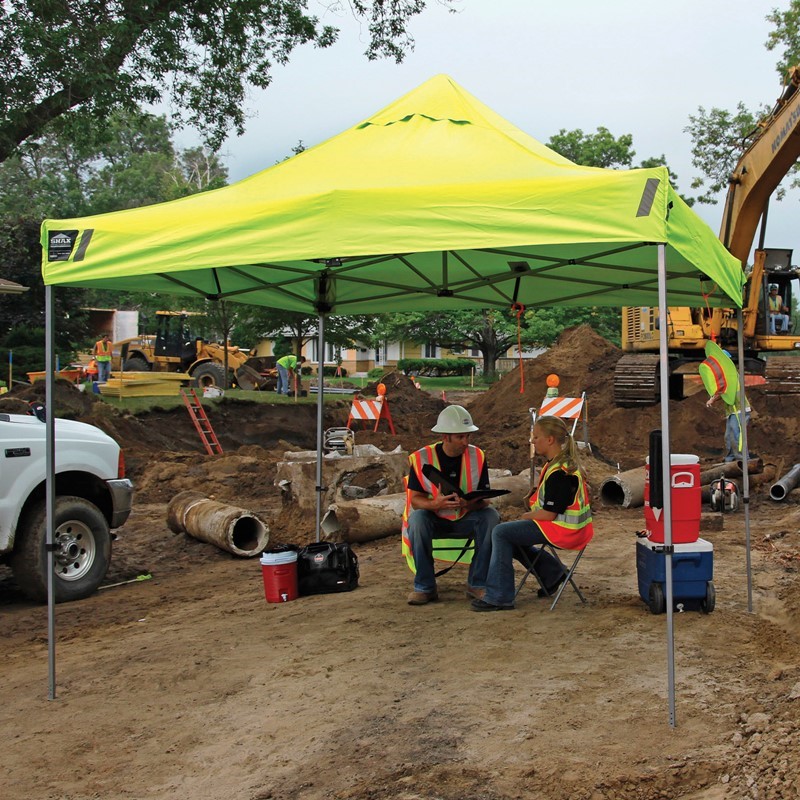 Workers sitting under a shade tent to keep cool