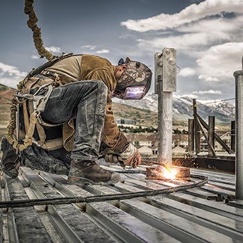 Worker kneeling and welding