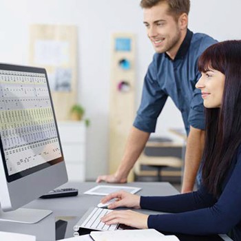 workers looking at reports on a computer