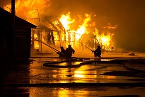 A picture of firefighters fighting a house on fire